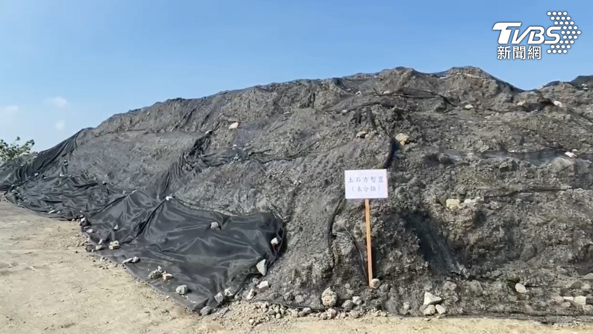 現場堆積的廢瀝青和砂石已形成小山般的高度,雖然覆蓋了一層塑膠網,仍可見底下裸露的大量砂石。(圖/TVBS)