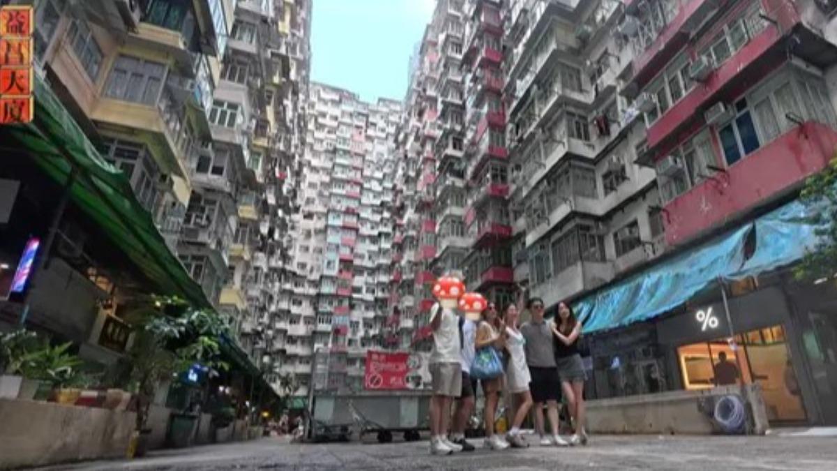 金針菇與家人們在香港益昌大廈「禁止拍照」告示牌前合照,引發網友熱議。(圖/翻攝自「韓勾ㄟ金針菇 찐쩐꾸」YT)