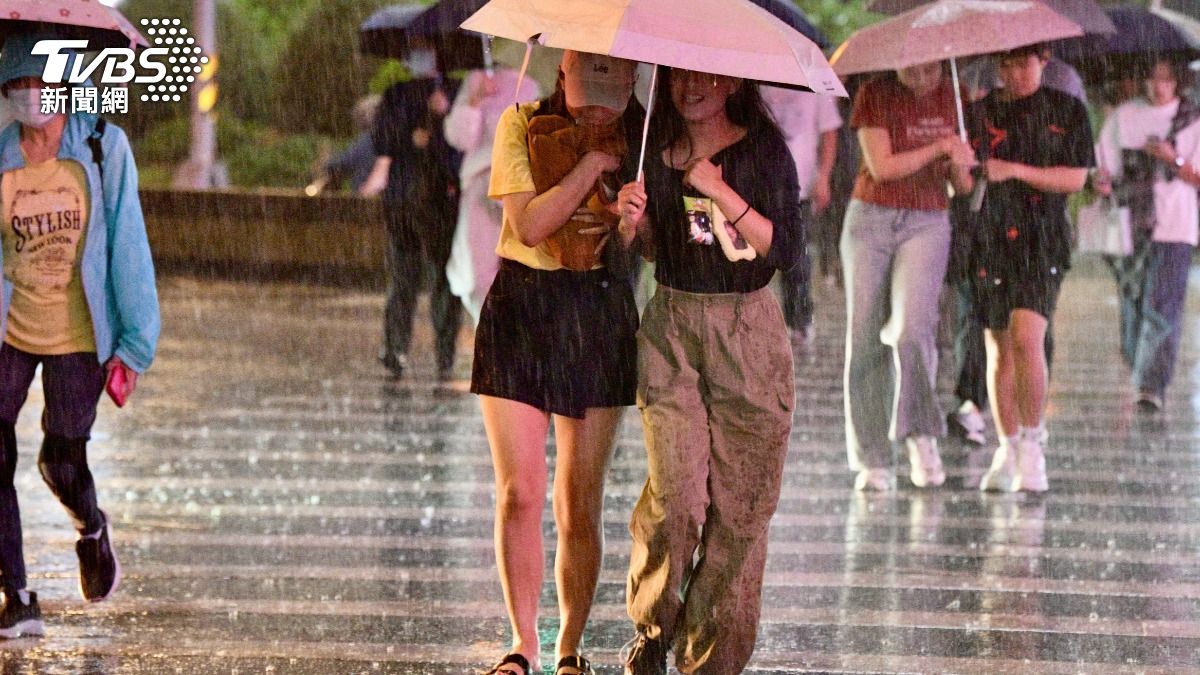台北市區今(19)晚間下起大雨,民眾紛紛撐起雨傘。(圖/胡瑞麒攝)