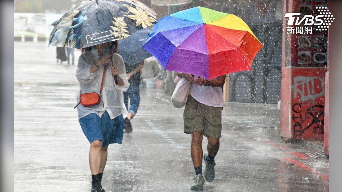 北部暴雨狂下,不少民眾冒雨上班。(圖/胡瑞麒攝)