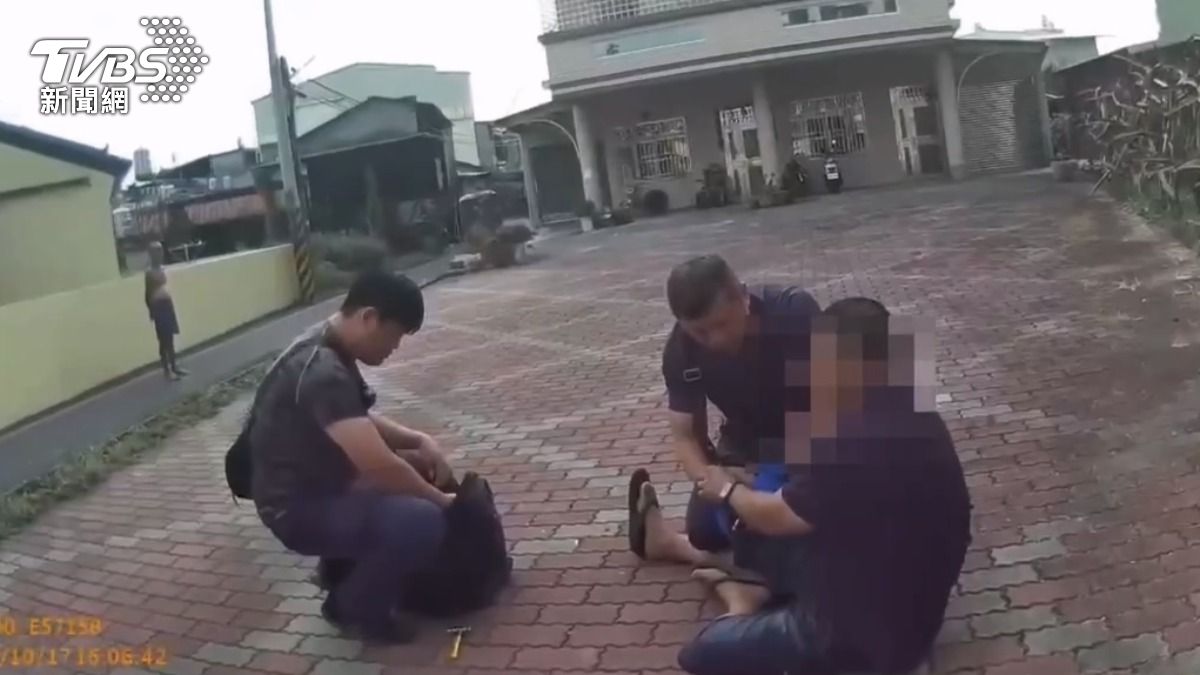 嫌犯一開始仍有不配合的情形，但很快就坐在地上讓警方上銬。（圖／TVBS）