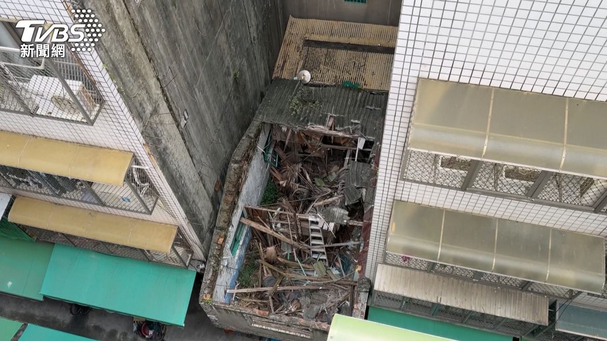 這棟戰地風格的透天厝位於高雄前鎮區的一處巷弄內，二樓以上部分已經「開天窗」，四周則是雜草叢生。（圖／TVBS）