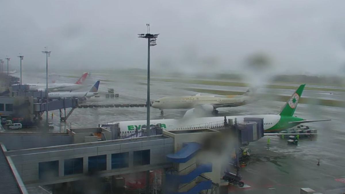 桃園機場北跑道觀景台即時影像,鏡頭都被雨打濕。(圖/翻攝自Taoyuan AirportYT)