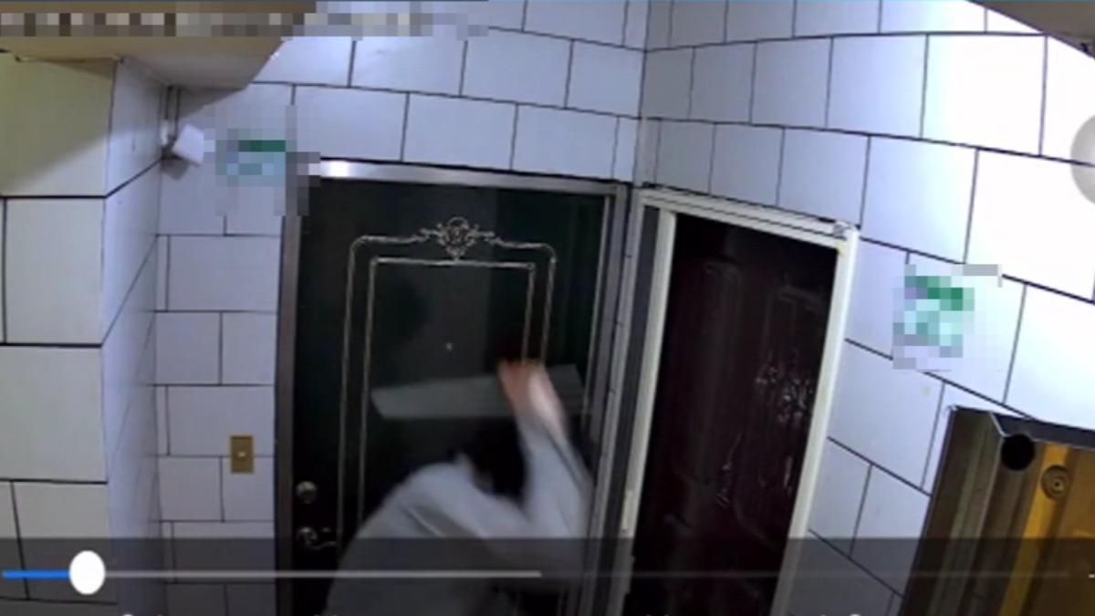 男子疑似不滿鄰居報案,拿鐵棒敲打住戶大門。(圖/住戶提供)