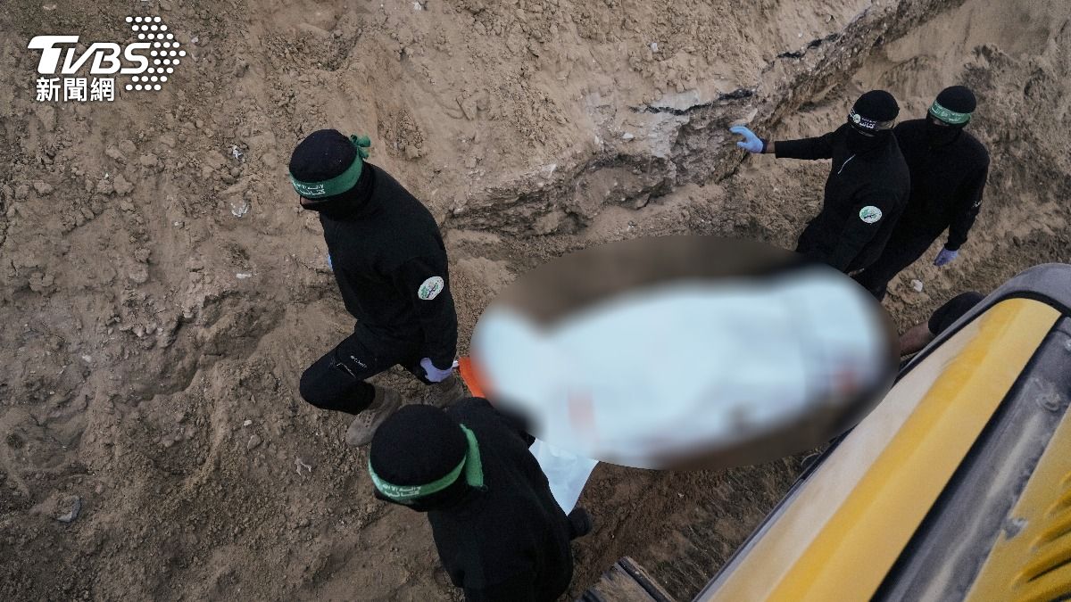 數名蒙面的哈瑪斯戰士從地道中出現,抬著一具以白色塑膠袋包裹的遺體,據信這是哈瑪斯原定今天交還的人質遺體。(圖/達志影像美聯社)