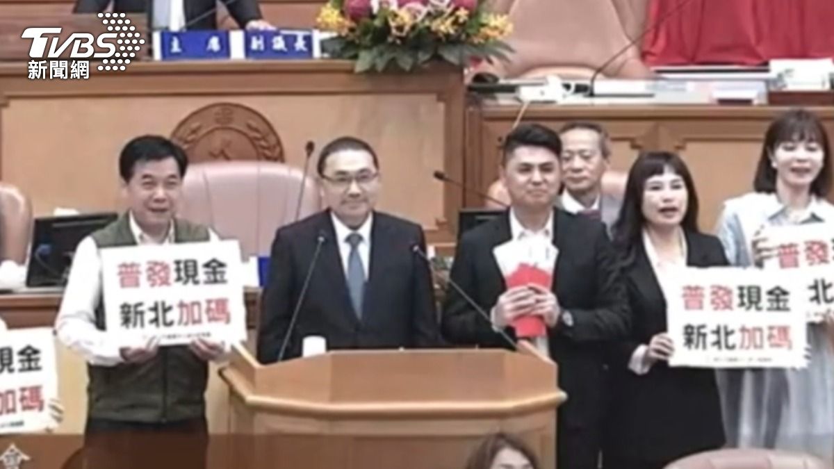 民進黨新北市議員,持玩具鈔票與新北市長侯友宜在議場合照。(圖/TVBS)