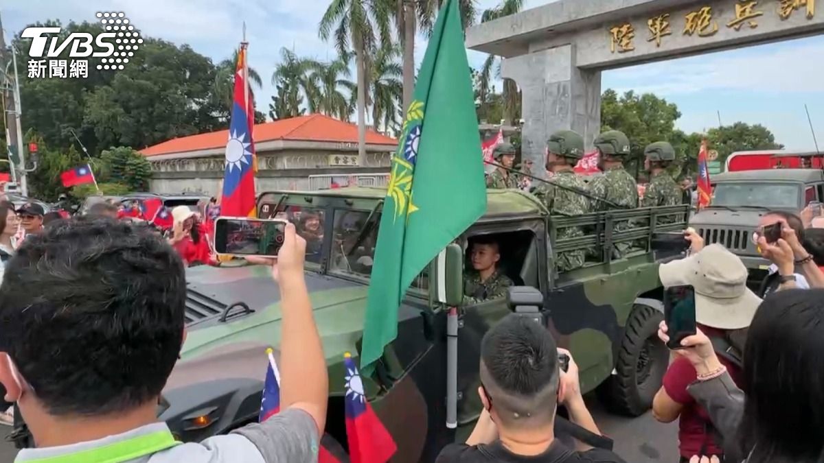 軍車載著部隊一輛接一輛駛出營區,軍人們向永康揮手道別,居民則舉旗歡送。(圖/TVBS)