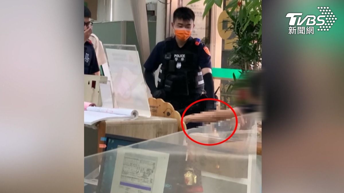 婦人懷疑戶頭少4000元,持菜刀到銀行理論,跟警方對峙。(圖/TVBS)