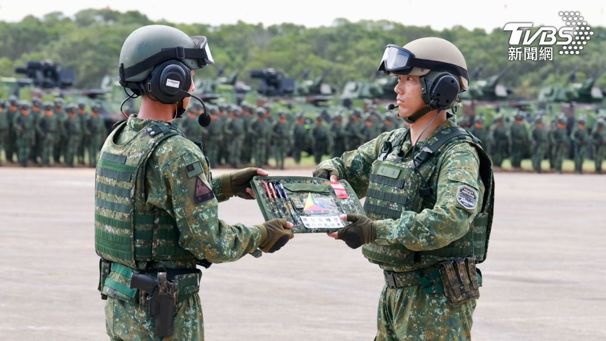 現役指揮CM11的戰車連長下車,將象徵作戰計畫的戰鬥手板交接給M1A2T戰車連長,象徵交接作戰任務。(圖/潘建樺攝)