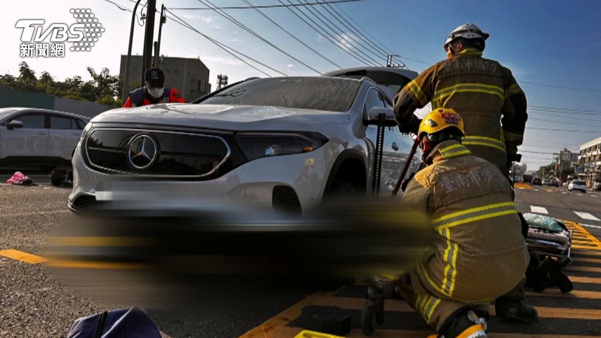 警消到達車禍場,消防隊還出動器材車,急忙把白色車輛抬升,因為另外一位60歲男騎士,已經被壓在車底,情況一度危急。(圖/TVBS)