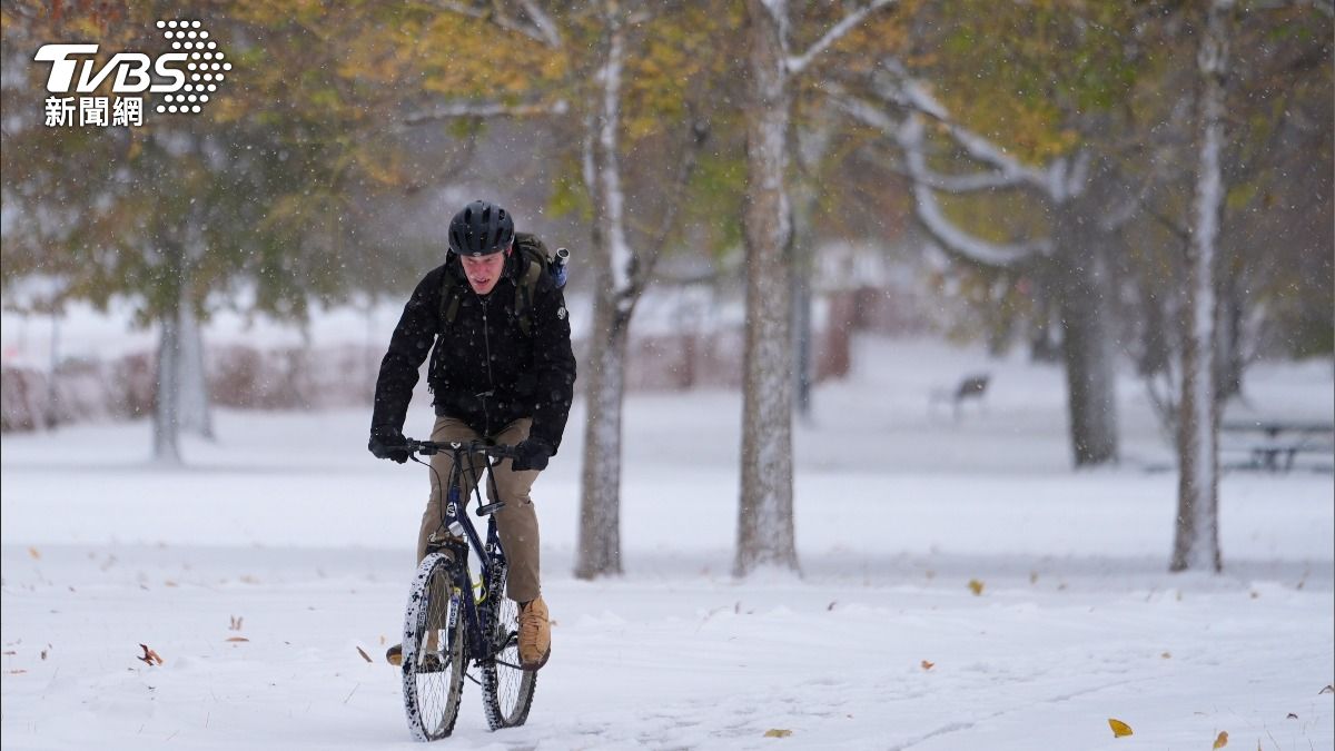 美國伊利諾迎來今年入冬以來第一場雪,芝加哥郊區民眾在覆蓋著白雪的地面騎著腳踏車。(圖/達志影像美聯社)