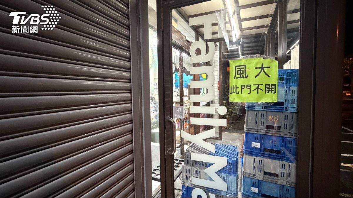 恆春街上超商風太大，鐵門拉一半防颱，照常營業。（圖／蘇憶歡攝）
