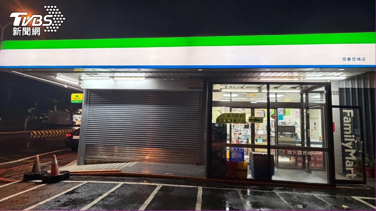 恆春街上超商風太大，鐵門拉一半防颱，照常營業。（圖／蘇憶歡攝）