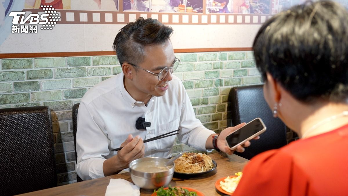吃小吃的空檔，洪孟楷拿出手機看的不是行程、講稿，而是打開相簿，看兩個女兒的照片和影片。（圖／柯勝雄攝）