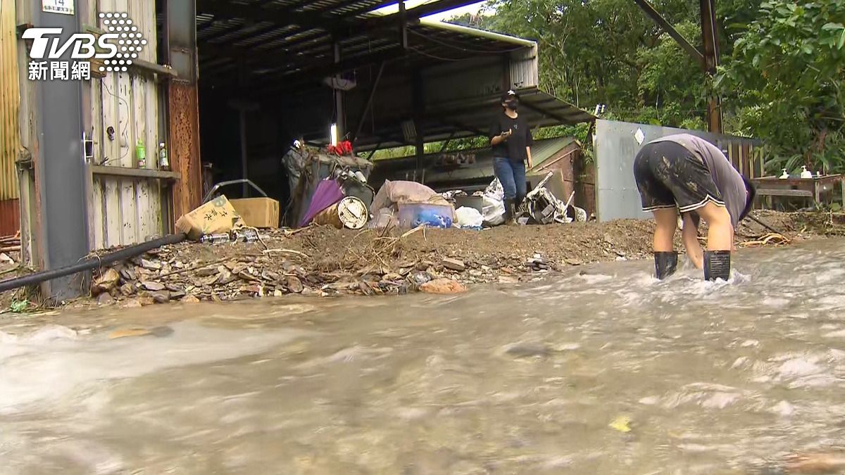 颱風過後卻堆滿泥土小石塊且積水嚴重。住家前空地堆放的物品被沖得亂七八糟。(圖/民眾提供)
