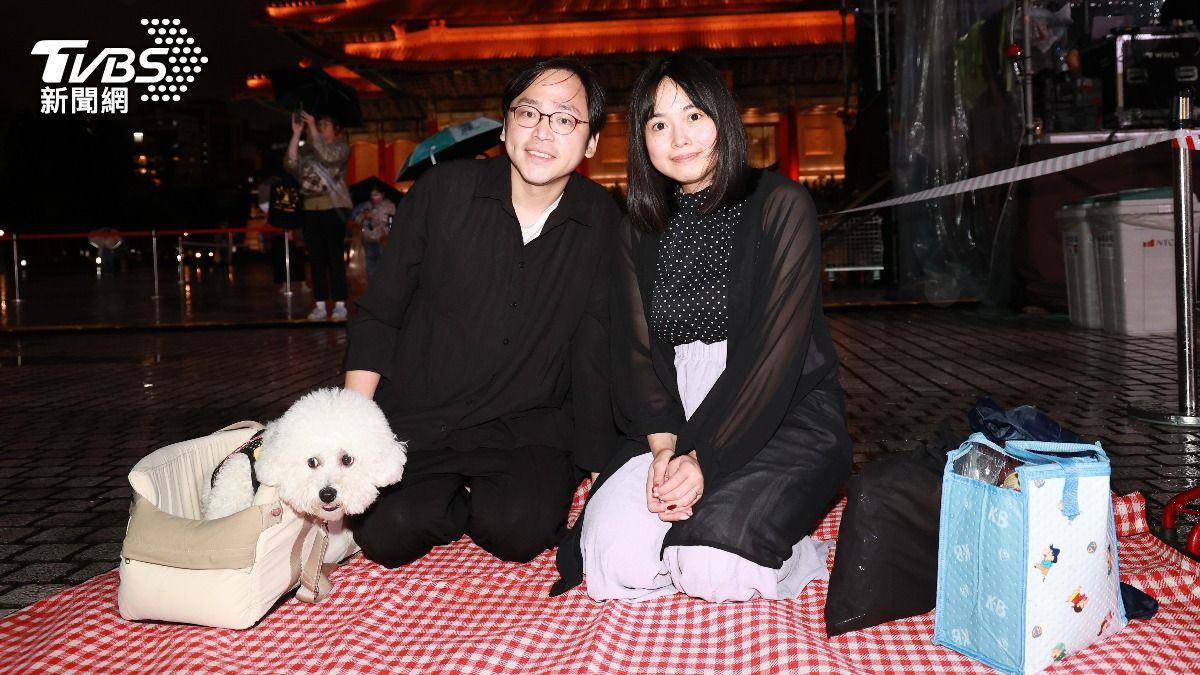 蔡小姐（右）和先生帶著愛犬一起欣賞戶外轉播。（圖／趙世平攝）