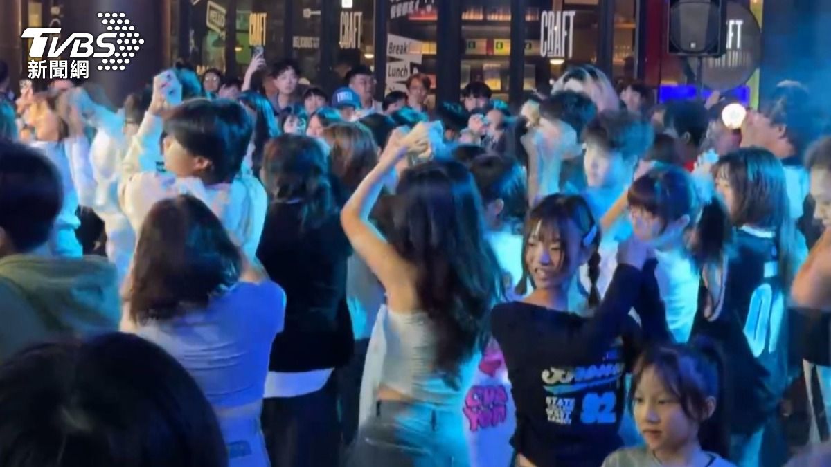 可以看到一聽到韓團TWICE的音樂,許多人都自動自發擺動身體,動作還相當一致(圖/TVBS)