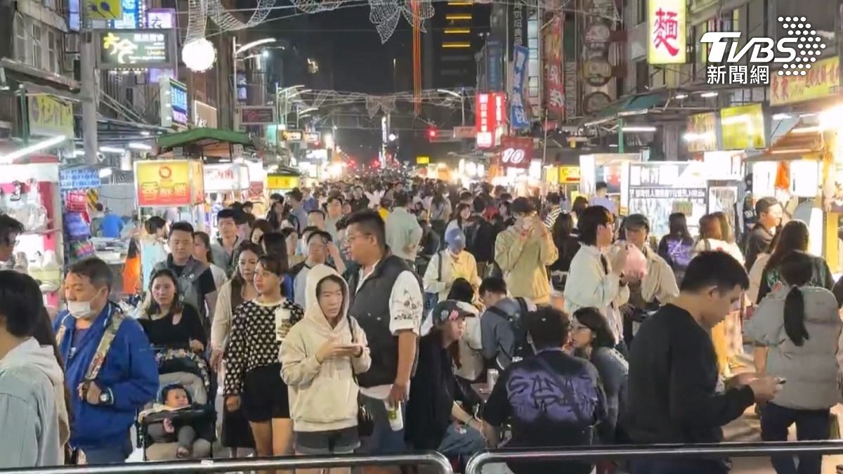 六合夜市湧入大批遊客,攤販三四名員工分工合作,忙到不行,不只內用坐滿,外帶區也是排好排滿(圖/TVBS)