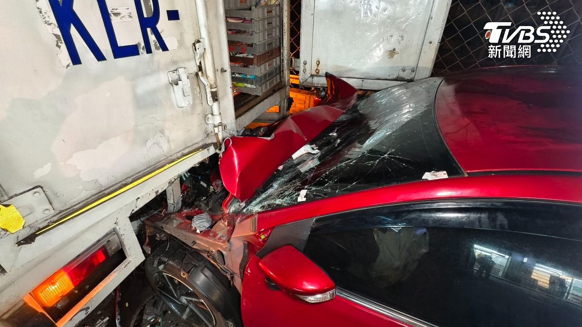 紅色自小客車撞擊物流司機後再插入車底，車頭受損嚴重、擋風玻璃碎裂。（圖／陳冠宇攝）