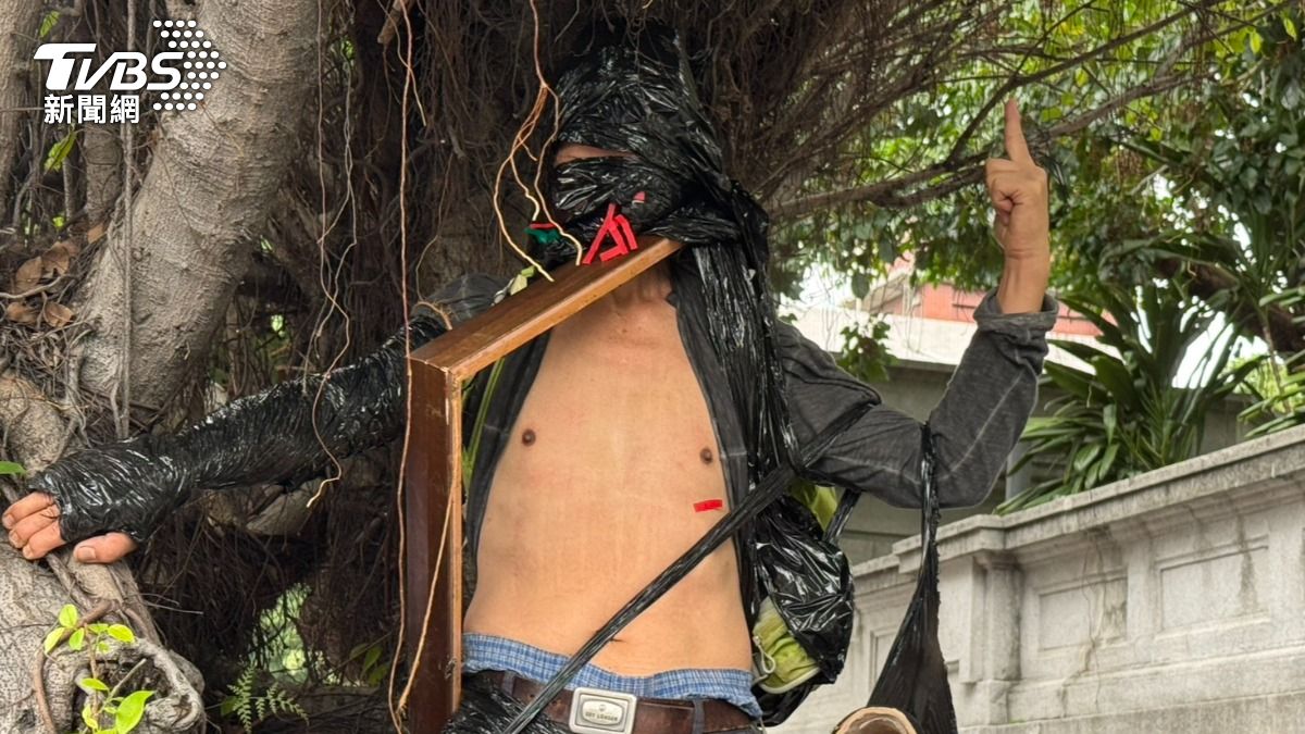 藝術家曾啓明把自己用黑膠捆起來,爬上樹喊出「No nature!No future」。(圖/陳怡潔攝)