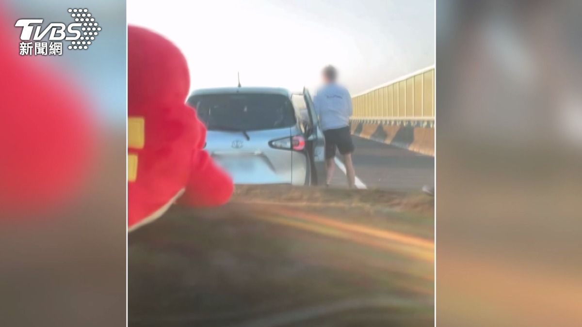 一輛白色休旅車外切到最右側車道後,一名外籍男子竟跳出車外,在路肩開始跳舞。(圖/民眾提供)