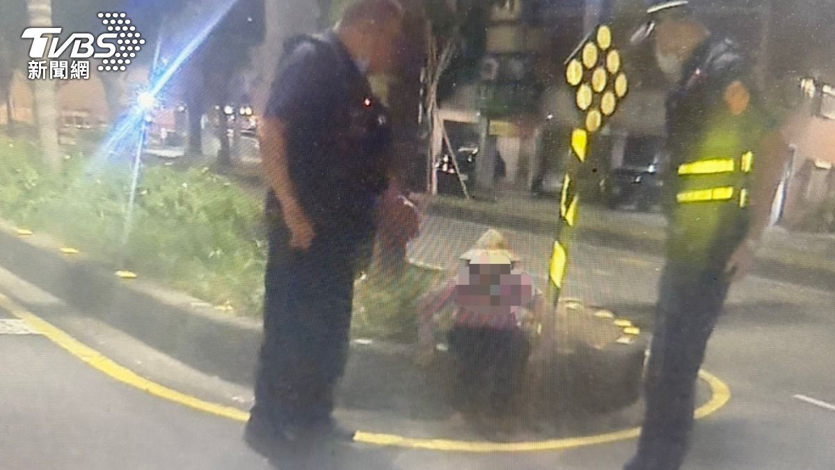 三輪車奶奶無助蹲分隔島。（圖／TVBS）