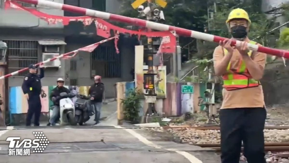 毒駕男棄車逃，釀平交道故障，員警、台鐵人員「手扛柵欄」苦撐。（圖／TVBS）