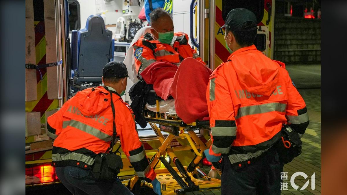 身穿救護員制服的男子臉露痛苦,被搬運上救護車送醫。(圖/香港01)