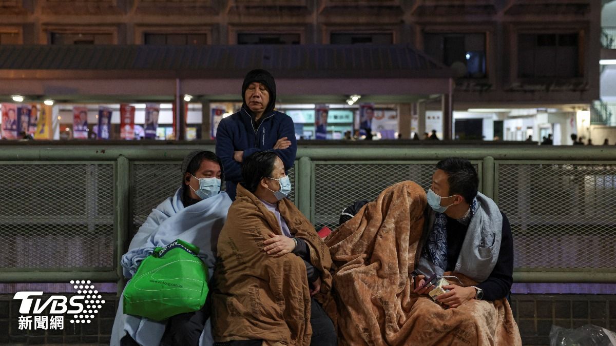 香港大埔發生五級大火,流離失所的居民裹著毛毯在附近聚集。 (圖/達志影像路透社)