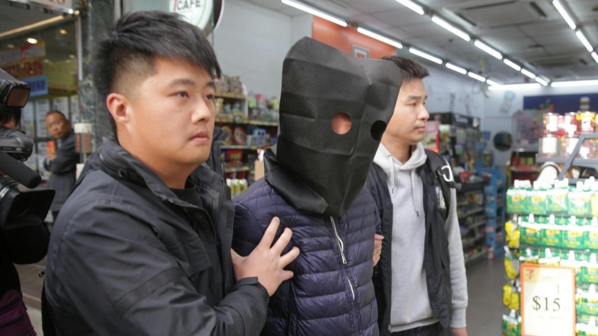 香港警方的新界北重案組27日對負責宏福苑大維修的建築工程公司「宏業」展開調查,有1名男子被黑布蒙頭帶走。(圖/翻攝自香港01)