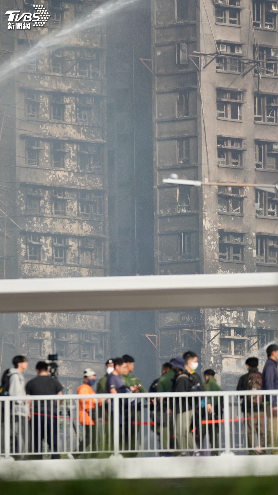 建築外牆被嚴重燻黑，消防水柱仍在持續灌救。（圖／區國強攝）
