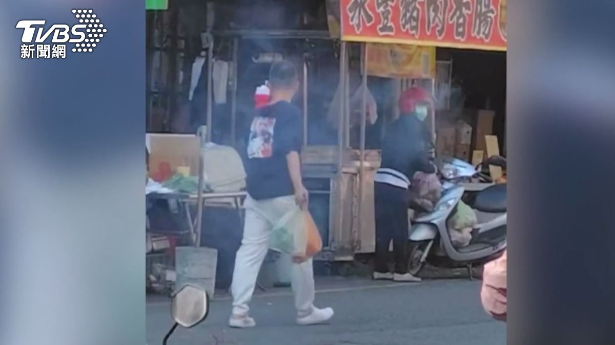 黑衣男子在市場內點燃鞭炮並隨意丟擲,一路「炸街」,嚇壞攤販和購物民眾。(圖/畫面翻攝 FACEBOOK 草屯人)