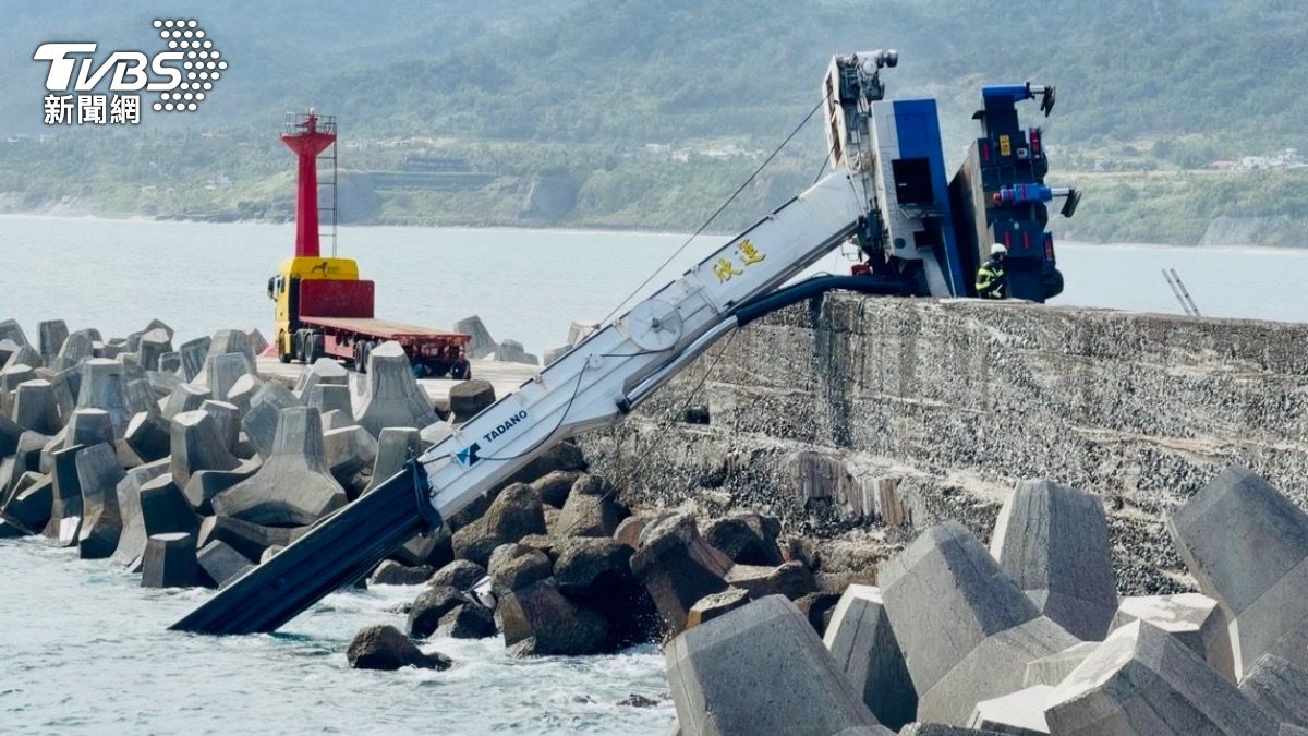 台東漁港吊放消波塊作業時,吊車意外自堤防處突然翻覆,吊臂連同抓起的配重塊一同墜海。(圖/TVBS)