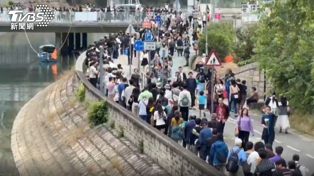 香港宏福苑大火奪走上百條生命，大批香港人趁著週末，到現場附近獻花悼念。(圖／TVBS 吳奎炎攝)