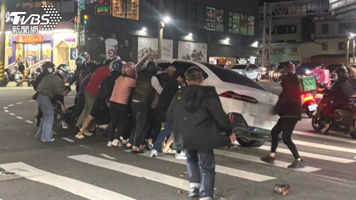 目睹事故的路人迅速反應,紛紛上前合力抬起汽車救人。(圖/TVBS)
