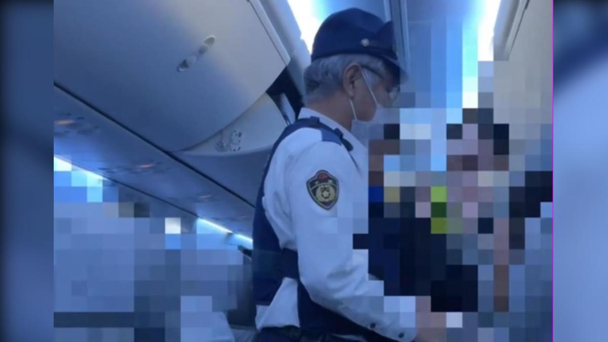 網傳警方帶走機上鬧事男子。(圖/極目新聞)