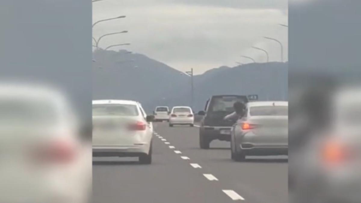 國道五號南下43公里處,有兩台車上的乘客在公路上伸出頭手,互丟不明物品。(圖/爆料公社二社)