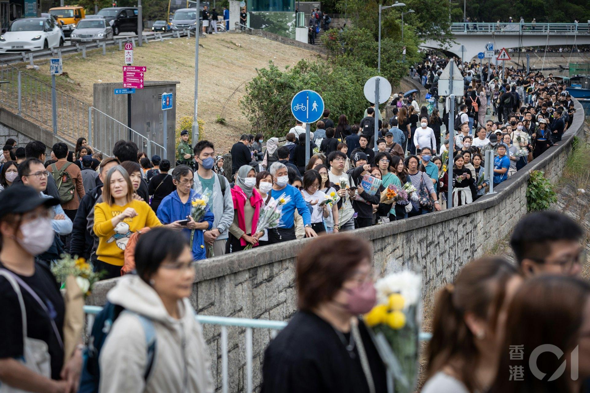 大批市民自發性的到大埔宏福苑火災災場附近的廣福邨獻花悼念罹難者。(圖/香港01提供)
