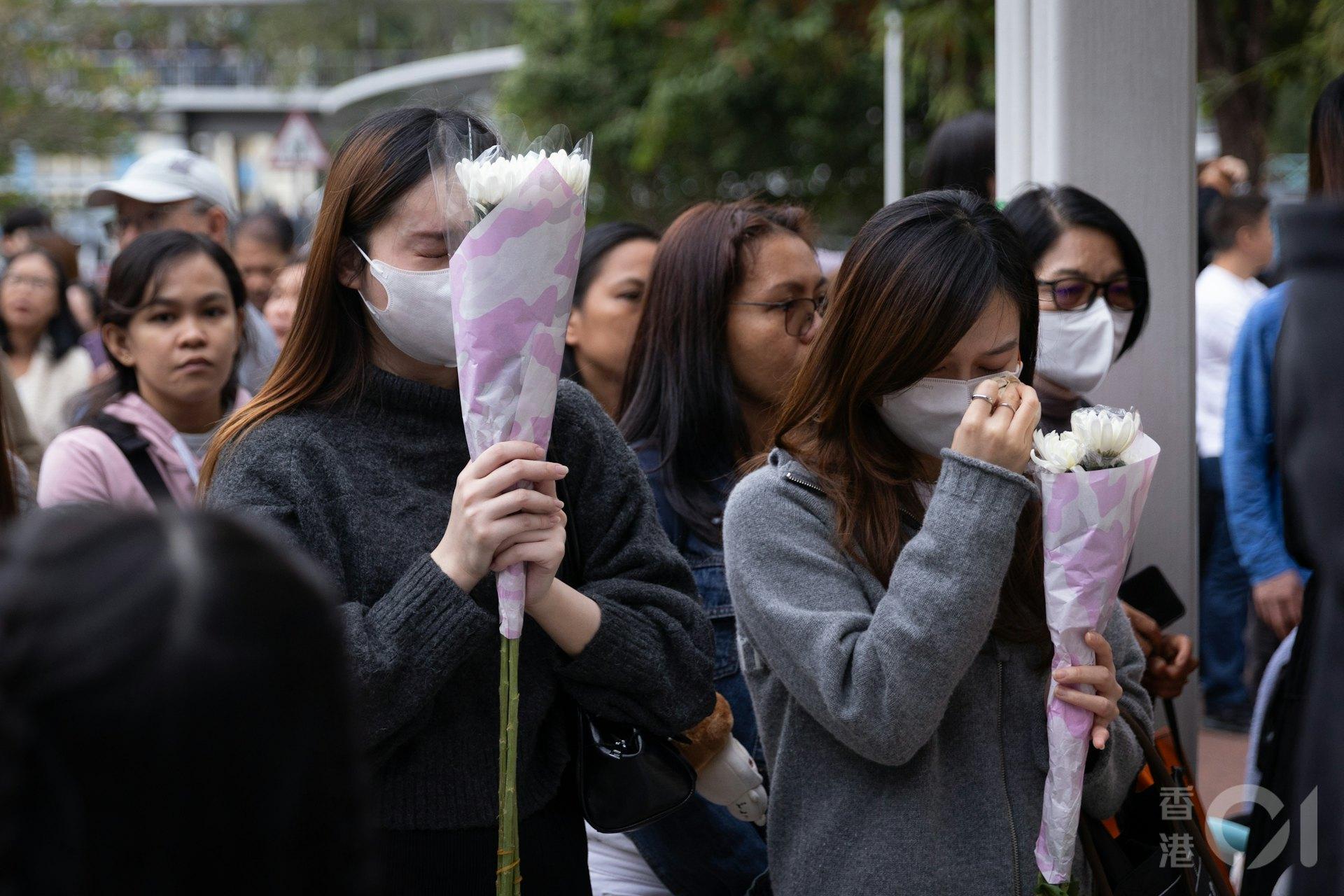 人人手持一束鮮花追悼死者,場面哀戚。(圖/香港01提供)