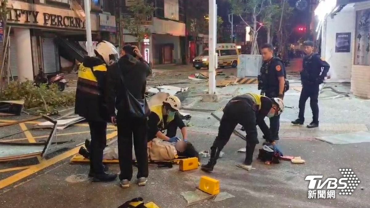 救護人員將受傷女子先安置於長背板上，並協助清理她臉上的玻璃碎渣。（圖／TVBS）