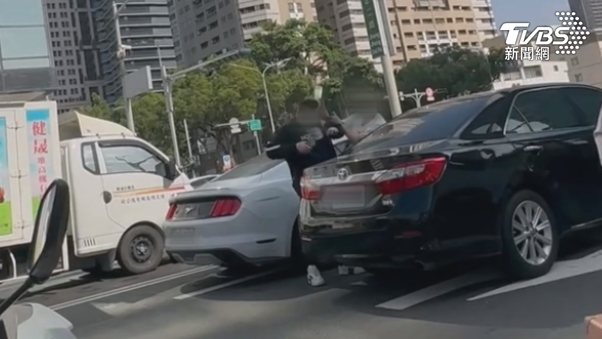 一名男子不滿後方駕駛按喇叭,雙方趁紅燈時下車理論,白衣男不只動口還動手,朝著對方噴灑辣椒水還砸水瓶(圖/民眾提供)