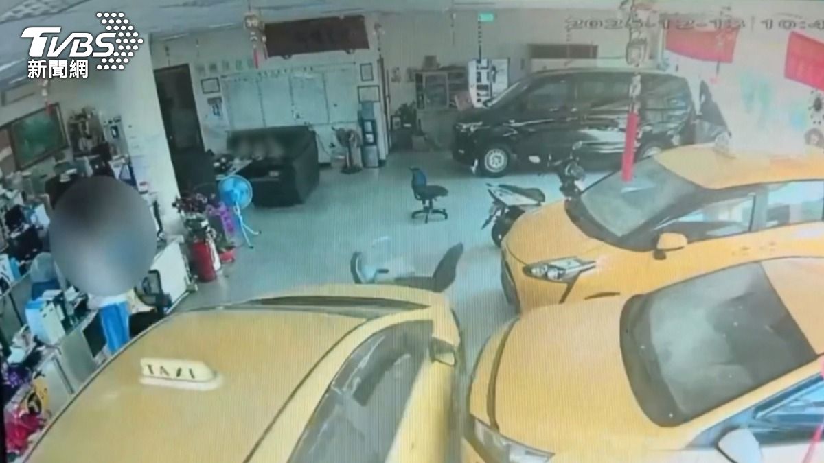 一輛燃燒著的計程車突然衝入車行，車行老闆兒子和媳婦緊急跳開避險。（圖／TVBS）