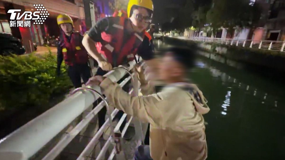 消防人員架設鋁梯協助兩人脫困。（圖／TVBS）