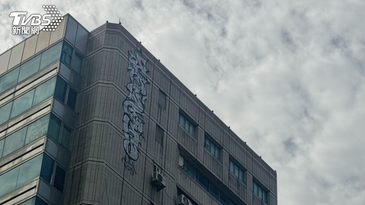 16層樓高的商辦大樓兩側的頂樓外牆上，突然冒出高空塗鴉。（圖／林冠丞攝）