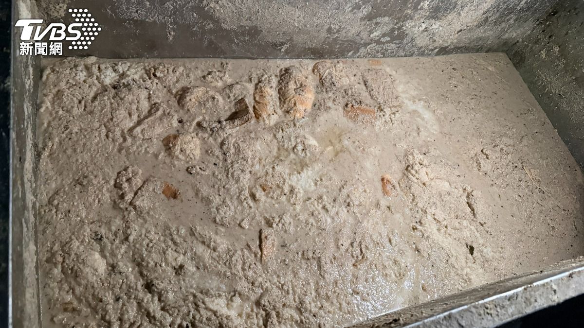 養豬場內發現以水混合飼料及麵包等物置於飼料槽推車中。(圖/TVBS)
