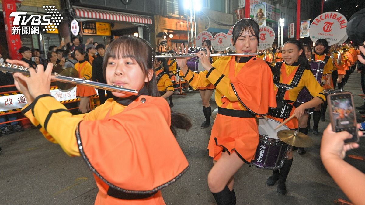 即使夜晚冷風刺骨,「橘色惡魔」依舊面帶笑容,踏著整齊步伐前進。(圖/胡瑞麒攝)