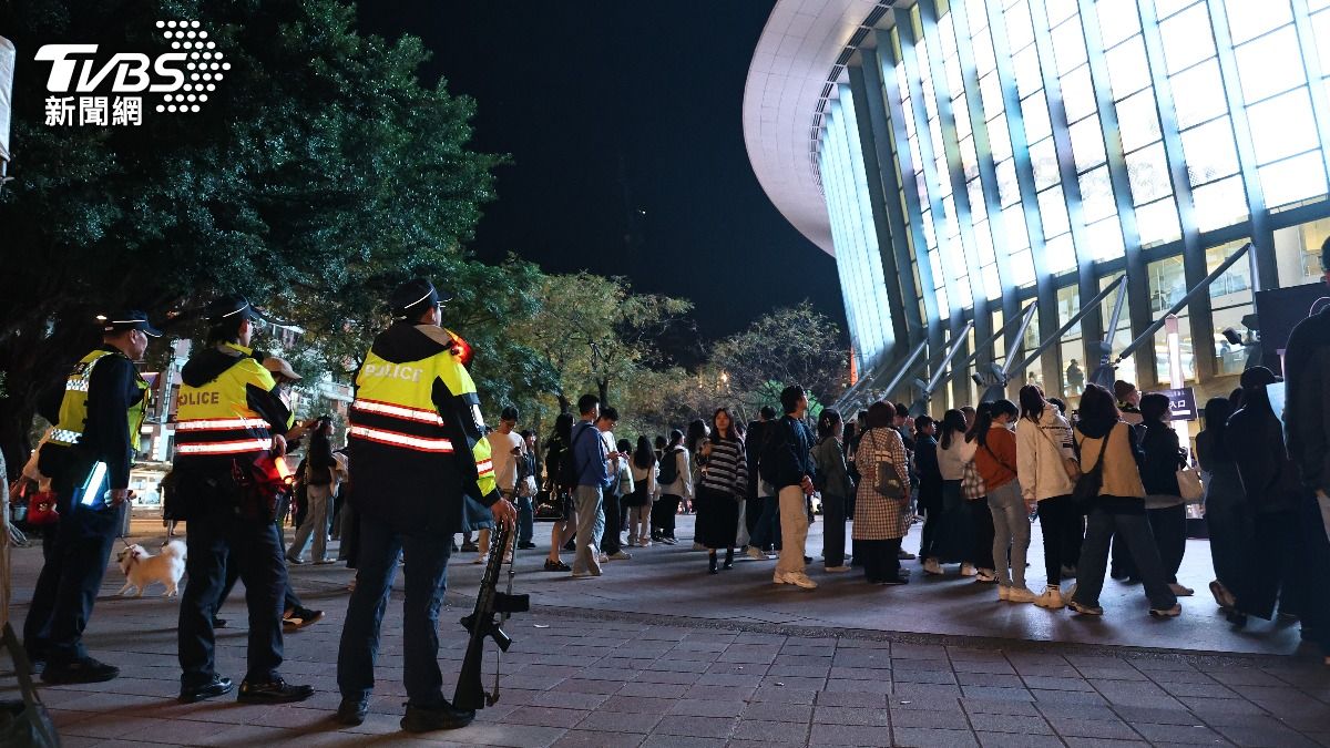 宇宙人粉絲排隊拍照,警方持長槍在附近查看秩序。(圖/張哲鳴攝)
