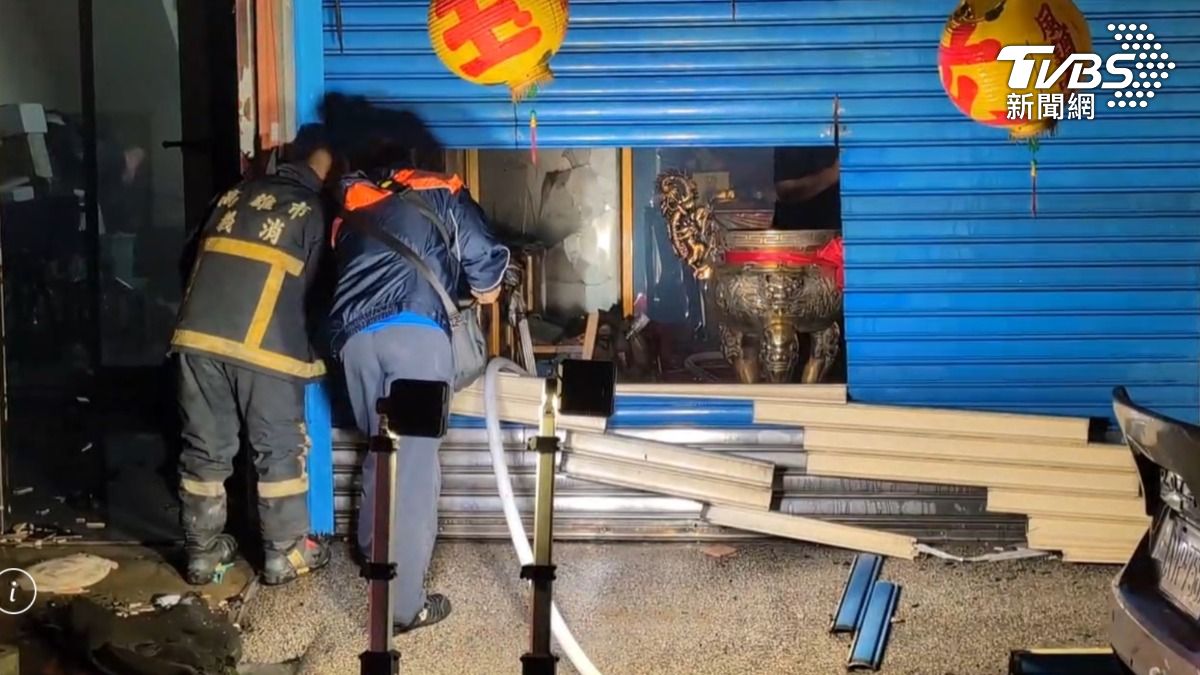 消防人員使用破壞器材將鐵捲門破壞，並進入屋內進行灑水灌救工作。（圖／TVBS）