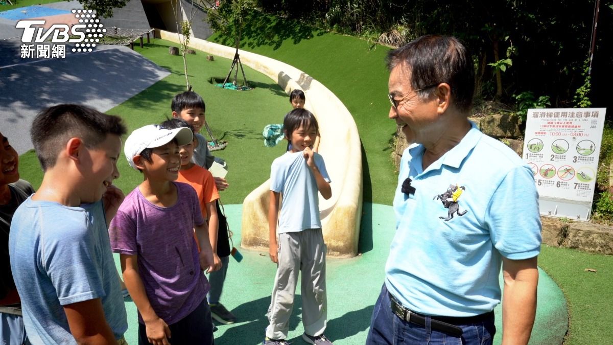 小朋友溜滑梯，遇到賴士葆。孩子們問：你做的？賴回我爭取的。（圖／柯勝雄）
