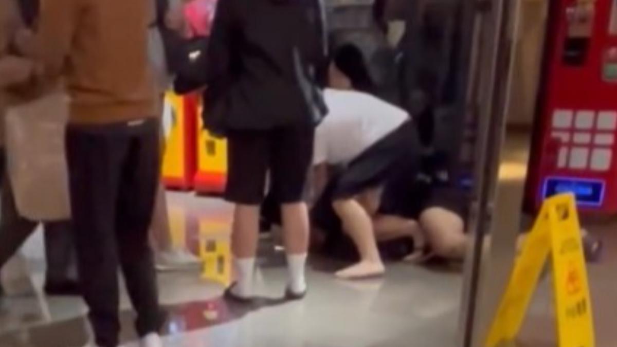 白衣男子將另一人壓制在身下,兩人打到鞋都不見了。(圖/翻攝自Threads@r9.uau)